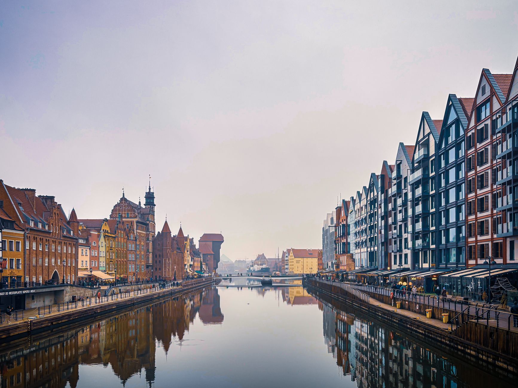 Gdańsk historic merchant houses reflected in the Motława River with the medieval crane at dusk, Poland