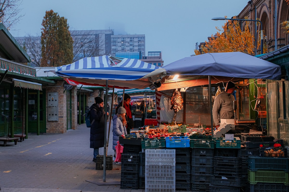 People walking past stalls at Hala Mirowska market hall, Warsaw, Poland