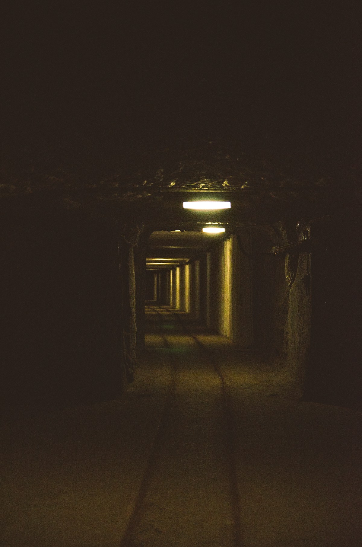 Long illuminated tunnel stretching into darkness in the Wieliczka Salt Mine, Poland
