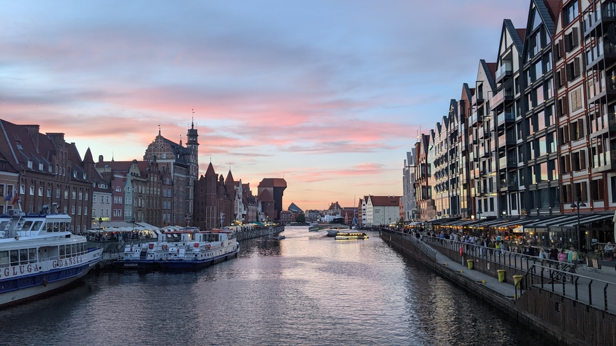 Gdańsk Motława waterfront with historic buildings and boats at sunset
