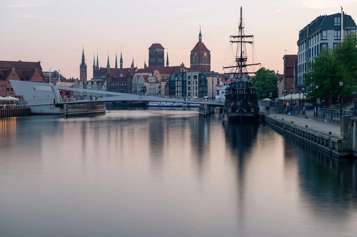 Gdańsk skyline at dusk seen from the Motława River with a tall ship in the foreground, Poland