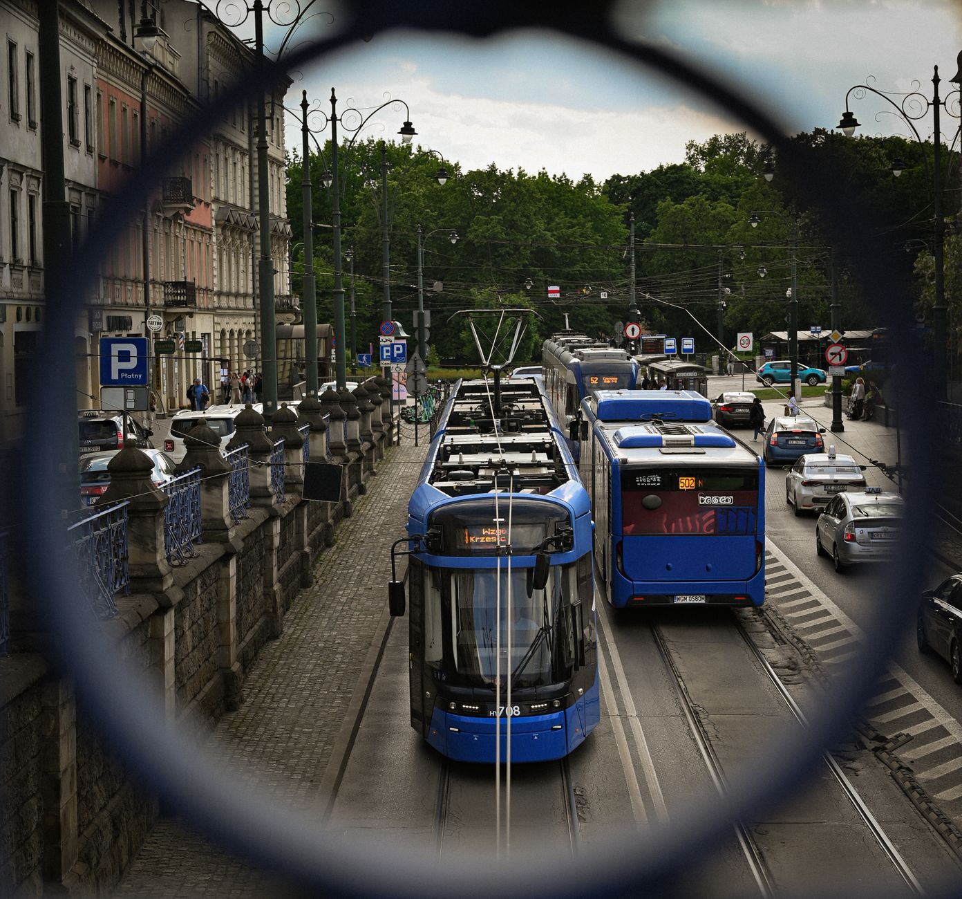 Blue Kraków tram and bus on a city street near the Old Town