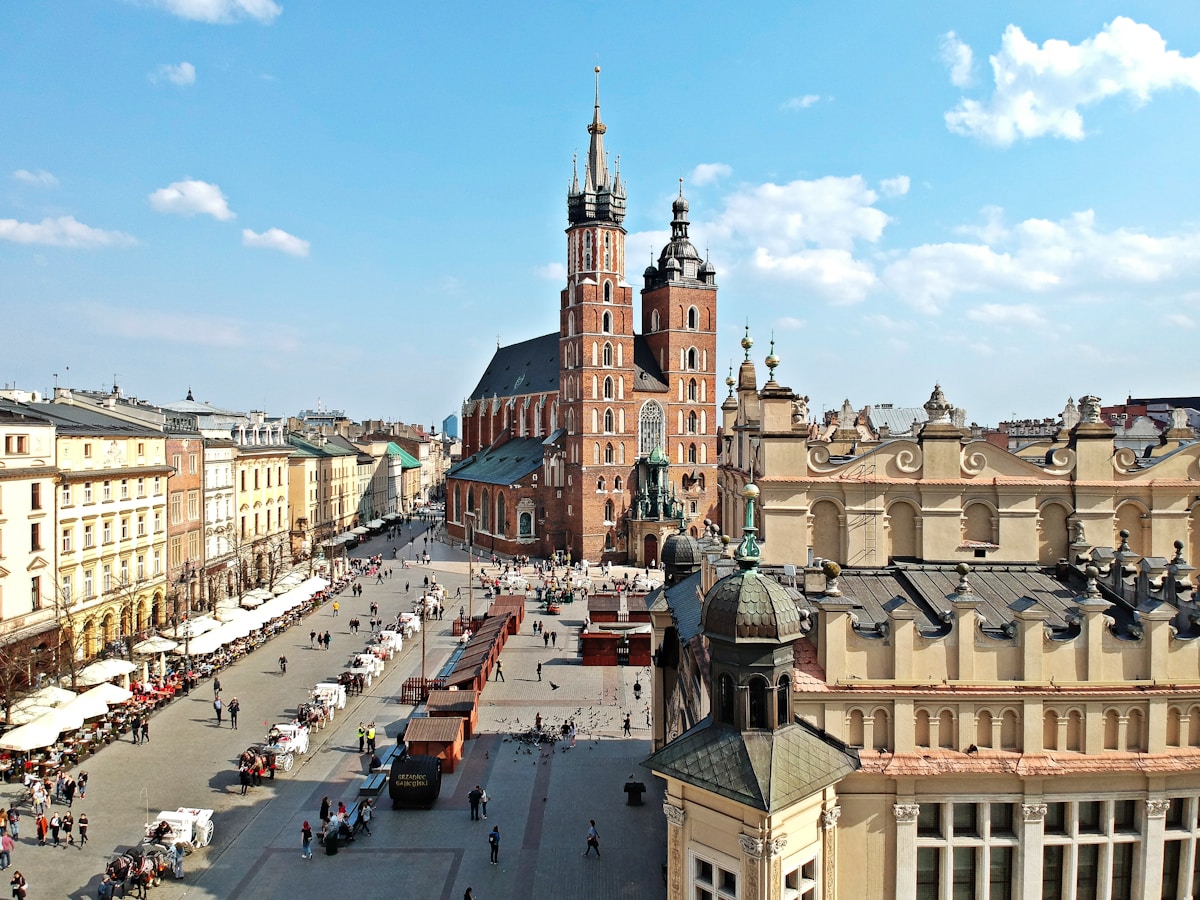 Kraków Main Market Square with St Mary's Basilica under blue sky, Poland