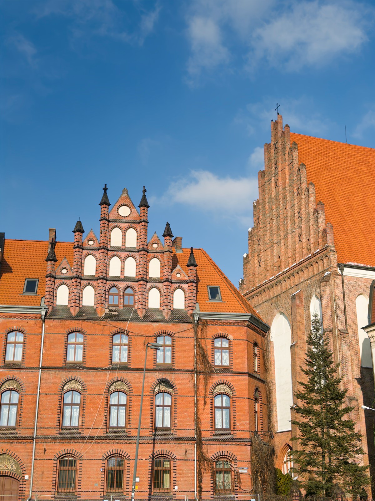 Historic brick buildings with orange tiled roofs in Wrocław, Poland