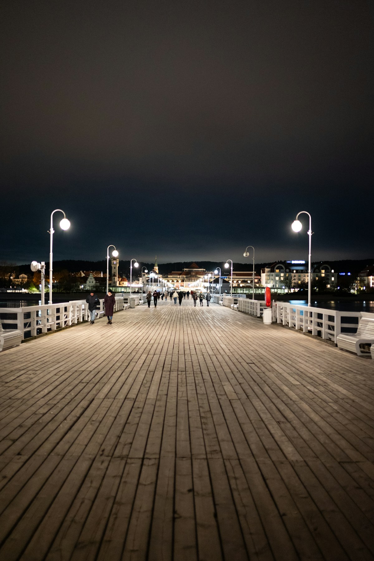 Sopot pier (Molo) illuminated at night with people walking, Poland