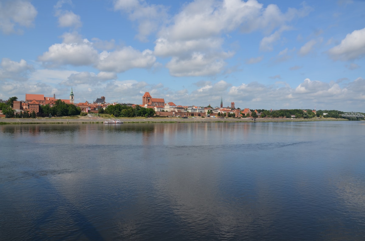 Toruń medieval old town skyline reflected in the Vistula River on a bright summer day, northern Poland