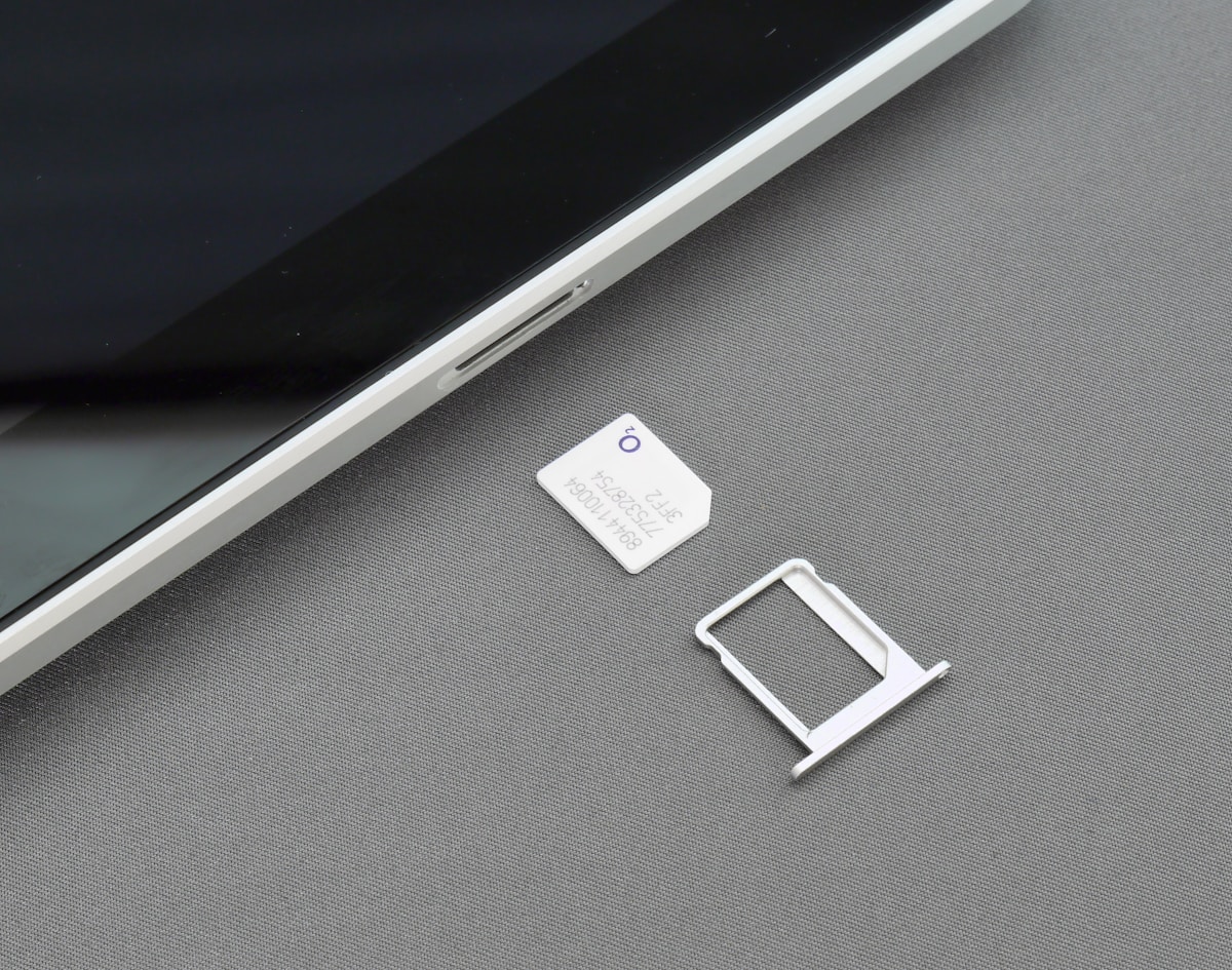 SIM card and SIM tray next to a smartphone - mobile connectivity in Poland