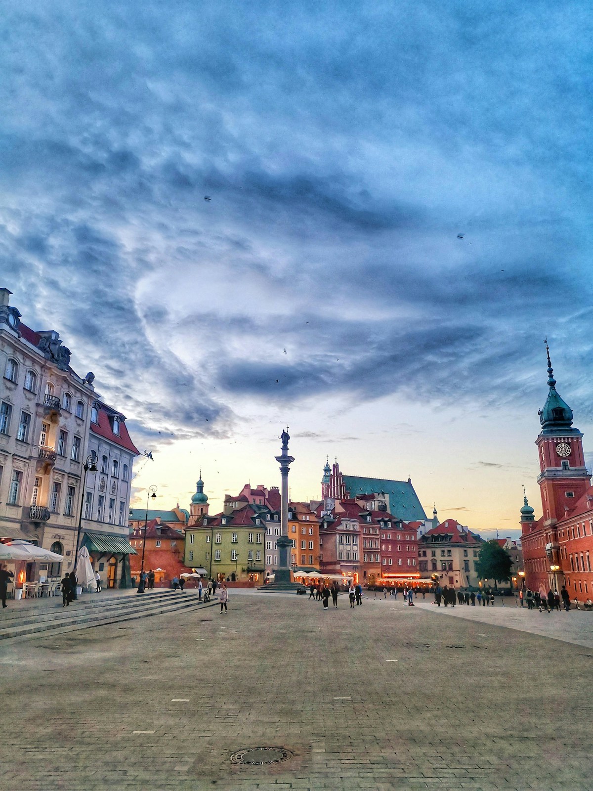 Early spring scene in Warsaw with people walking past historic buildings in March