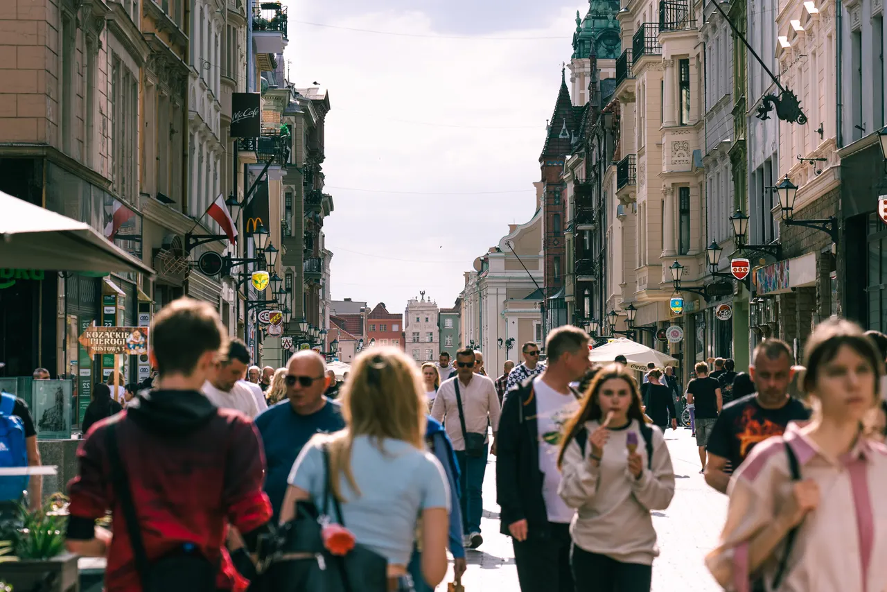 Busy pedestrian shopping street with cafés and shops in a Polish city