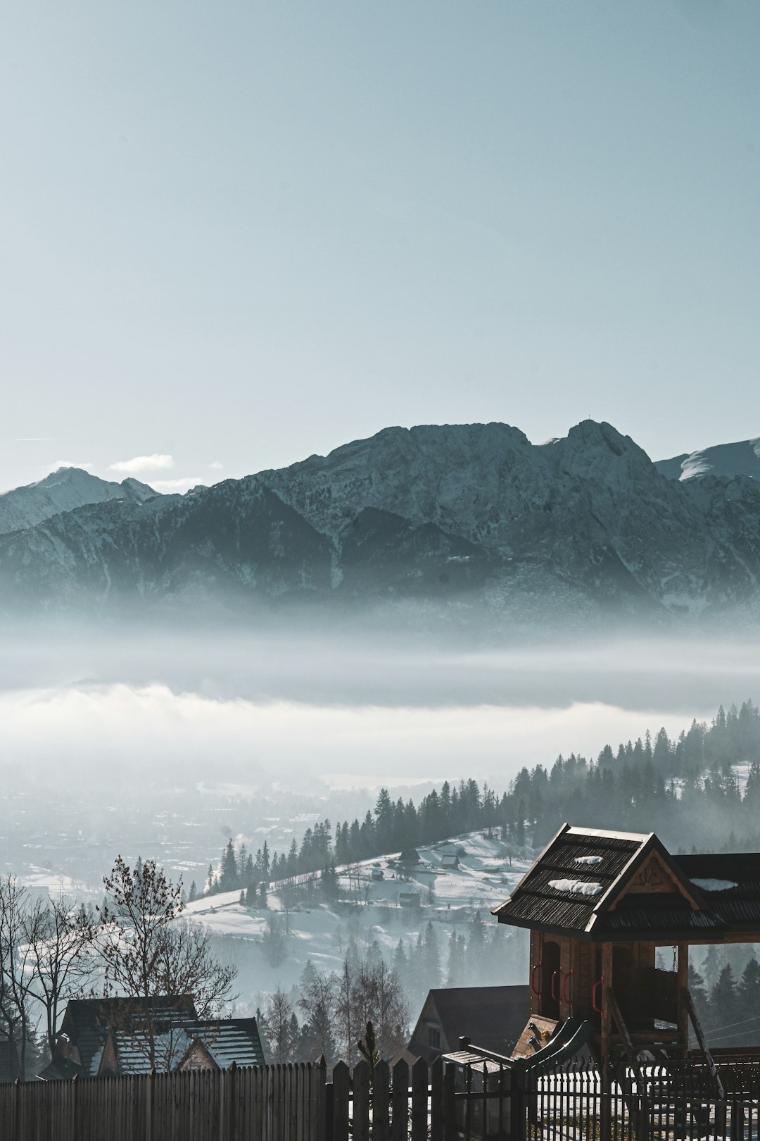 Zakopane wooden houses and Tatra Mountains in winter mist, Poland